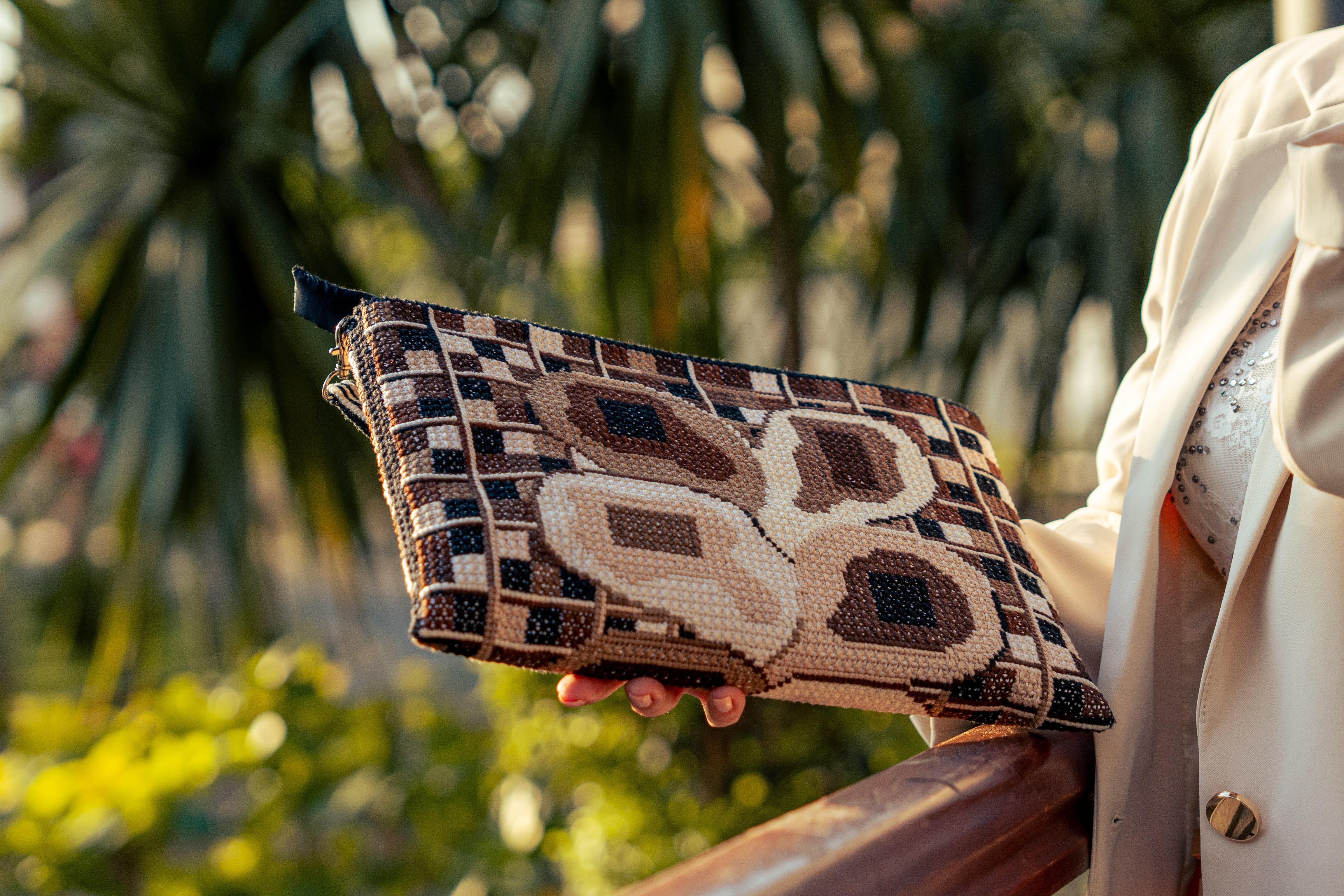 Perfection of close-up of golden chain decorated by floss on the designer fashion bag